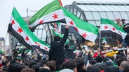 Zahlreiche Menschen feiern am Hachmannplatz am Hauptbahnhof den Sturz von Syriens Machthaber Assad. © picture alliance/dpa | Bodo Marks Foto: Bodo Marks