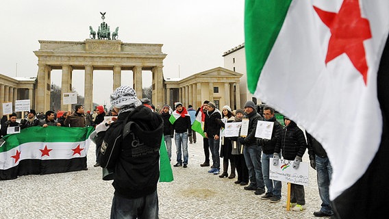 Demonstranten gegen das syrische Regime vor dem Brandenburger Tor in Berlin. © dpa picture alliance Foto: Maurizio Gambarini