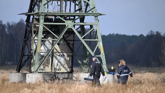 Polizei ermittelt an einem beschädigten Strommast auf einem Feld in Brandenburg. © dpa-Bildfunk Foto: Sebastian Gollnow/dpa