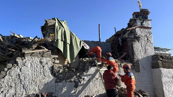 Auf diesem von der Nachrichtenagentur Xinhua veröffentlichten Foto suchen Rettungskräfte nach einem Erdbeben in der Changsuo-Gemeinde Dingri in Xigaze in der Autonomen Region Tibet im Südwesten Chinas nach Überlebenden. © Anonymous/Xinhua/AP/dpa 