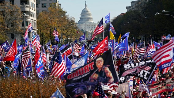 Anhänger von US-Präsident Donald Trump halten amerikanische Fahnen bei einer Protestveranstaltung in Washington. © dpa-Bildfunk/AP Foto: Julio Cortez