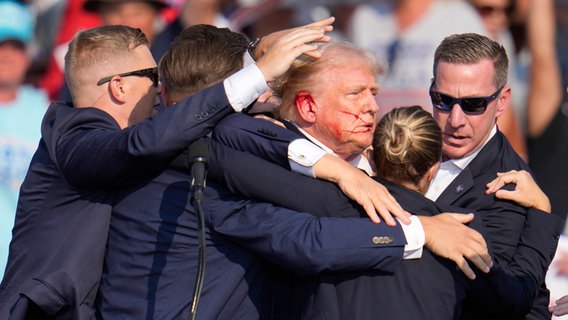 Der republikanische Präsidentschaftsbewerber und ehemalige US-Präsident Donald Trump mit blutendem Ohr © Gene J. Puskar//AP/dpa Foto: Gene J. Puskar/