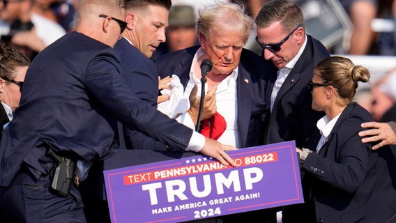 Donald Trump wird nach Schüssen auf ihn von Agenten des US-Geheimdienstes Secret Service umringt. © Gene J. Puskar/AP/dpa 