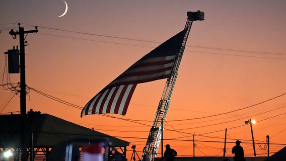 Eine US-Flagge weht in der Abenddämmerung. © dpa-Bildfunk/AP Foto: Alex Brandon