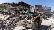 In Antakya in der Türkei, wo das Erdbeben vor fast sechs Monaten schwere Schäden anrichtete, wird Schutt weggeräumt. © Bradley Secker/dpa 