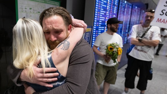 Patrick K. wird nach seiner Landung auf dem Flughafen in Frankfurt von seiner Mutter umarmt. © Boris Roessler/dpa 