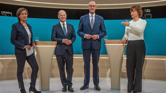 Die Fernsehmoderatorinnen Sandra Maischberger und Maybrit Illner stehen in einem TV-Studio neben Bundeskanzler Olaf Scholz (SPD) und Unions-Kanzlerkandidat Friedrich Merz. © dpa bildfunk/dpa-Pool Foto: Michael Kappeler