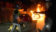 Ein Polizeiauto brennt, als Beamte nach einem gewalttätigen Protest in den Straßen von Hartlepool eingesetzt werden. © PA Wire/dpa Foto: Owen Humphreys