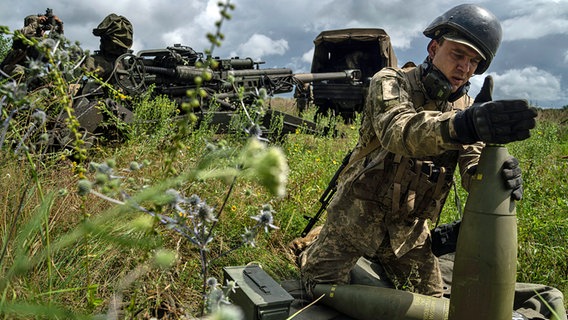 Ein ukrainischer Soldat installiert einen Zünder für eine 155-mm-Artilleriegranate an einer Haubitze des Typs M777 aus US-Produktion. © AP Foto: Evgeniy Maloletka