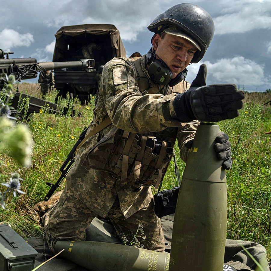 Ein ukrainischer Soldat installiert einen Zünder für eine 155-mm-Artilleriegranate an einer Haubitze des Typs M777 aus US-Produktion. © AP Foto: Evgeniy Maloletka