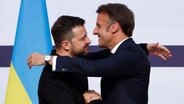 Der ukrainische Präsident Wolodymyr Selenskyj (l) und der französische Präsidenten Emmanuel Macron umarmen sich © Yoan Valat/Pool EPA/AP/dpa Foto: Yoan Valat