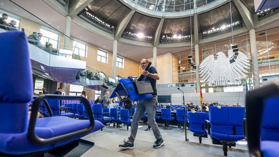 Handwerker bauen den Plenarsaal im Deutschen Bundestag für die konstituierende Sitzung des 21. Deutschen Bundestag und die neue Legislaturperiode um. Die Sitzverteilung im neuen Bundestag wird nach den Beratungen im Ältestenrat neu aufgebaut. © dpa Bildfunk Foto: Michael Kappeler