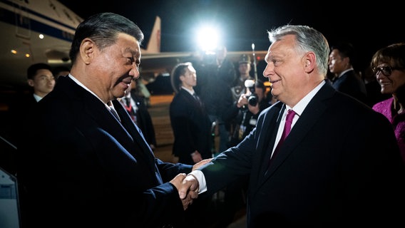 Der ungarische Ministerpräsident Viktor Orban begrüßt den chinesischen Präsidenten Xi Jinping auf dem Flughafen von Budapest. © picture alliance/dpa/Hungarian Prime Minister's Office/AP Foto: Vivien Cher Benko