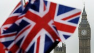Britische Flaggen wehen in der Nähe des berühmten Uhrturms Big Ben. © AP/dpa Foto: Matt Dunham