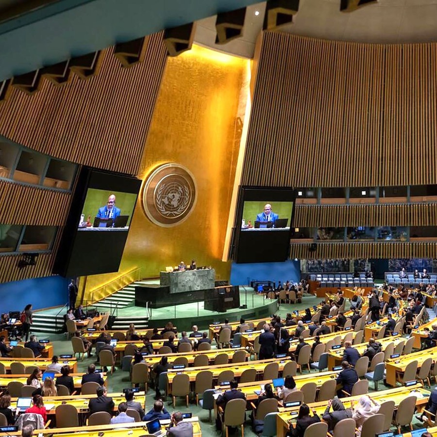 Dennis Francis (links am Podium und auf den Bildschirmen), Präsident der 78. Sitzung der Generalversammlung der Vereinten Nationen (UN), leitet die wieder aufgenommene 10. Dringlichkeitssondersitzung zum Thema «Illegale israelische Aktionen im besetzten Ost-Jerusalem und dem Rest des besetzten palästinensischen Gebiets». © picture alliance/dpa/UN Photo | Manuel Elias 