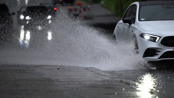 Ein Auto fährt durch eine große Wasserlache. © dpa Foto: Federico Gambarini