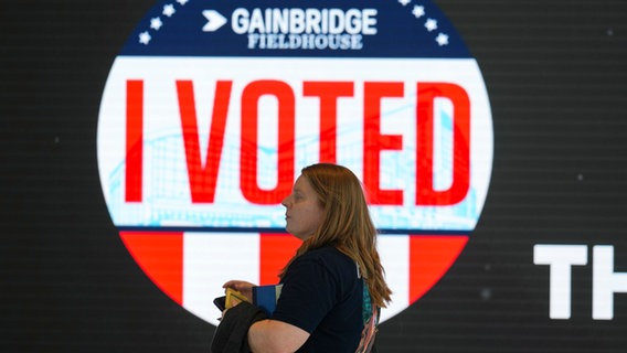 Eine Wählerin läuft vor einem Plakat entlang mit der Aufschrift "I voted" © AP Foto: US-Wahl: So läuft das Rennen um das Präsidentenamt