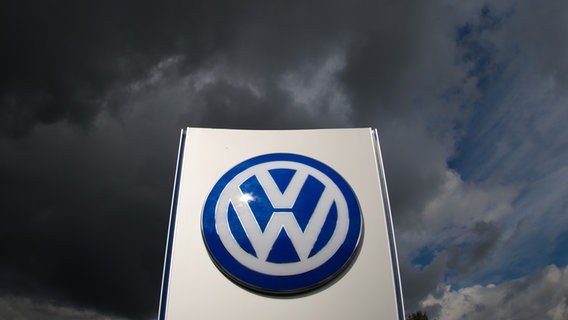 Dunkle Wolken ziehen über ein VW-Logo © picture alliance / dpa Foto: Julian Stratenschulte