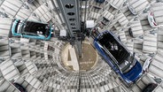 Die Volkswagen-Elektroautos ID.3 (l) und ID.4 stehen bei einem Pressetermin auf einer Transportplattform in einem Autoturm der Autostadt. © picture alliance Foto: Peter Steffen