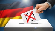 Wahlkarte mit Wahlkreuz wird in eine Wahlurne gesteckt, dahinter eine Deutschlandflagge (Bildmontage) © Fotolia.com Foto: mozZz, niyazz