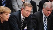 Bundeskanzlerin Angela Merkel, Präsidentschaftskandidat Christian Wulff und der CSU-Vorsitzende Horst Seehofer sitzen während der Wahl des Bundespräsidenten im Berliner Reichstag © dpa Foto: Hannibal Hanschke