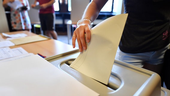 Eine Wählerin wirft den Stimmzettel in die Wahlurne bei der Stimmabgabe für die Landtagswahl in einem Wahllokal des Wahlbezirk Dresden-Prohlis im Jugendzentrum PEP. © picture alliance Foto: Martin Schutt