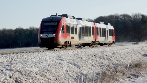 Ein Zug der Nordbahn fährt bei winterlichen Verhältnissen auf der Strecke zwischen Aukrug und Hohenwestedt. © dpa-Bildfunk Foto: Carsten Rehder, dpa