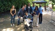 Richard Bielefeldt (sitzt im Rollstuhl) und ehemalige Kollegen von ihm bei einem Gruppenbild im Tierpark Hagenbeck in Hamburg. © NDR Foto: Wiebke Neelsen