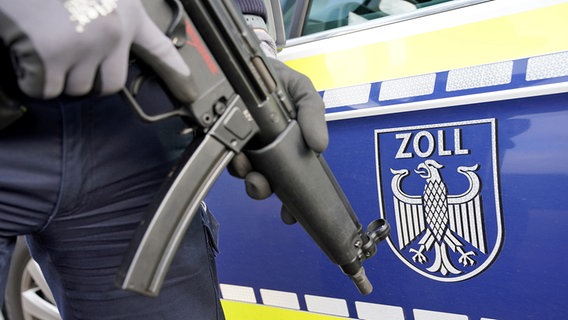 Ein bewaffneter Zollbeamter steht vor einem Auto mit der Aufschrift "Zoll". © dpa picture alliance Foto: Marcus Brandt