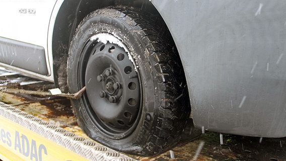 Ein Auto mit platten Reifen auf einem Abschleppwagen. © NDR Foto: Stefan Tretropp