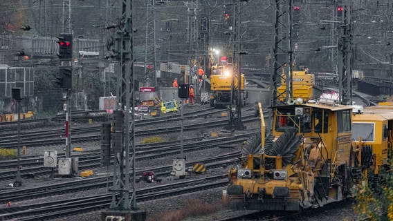 Auf einer gesperrten Bahnstrecke sind Arbeiter mit schwerem Gerät im Einsatz © picture alliance/dpa Foto: Markus Scholz