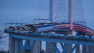 Fahrzeuge stehen im Morgenrot auf der Rügenbrücke. Die Initiative "Unternehmeraufstand MV" hat zeitweise die Rügenbrücke blockiert. © dpa Foto: Stefan Sauer
