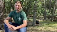 Landwirt Daniel Willnat sitzt zusammen mit seinen Bioputen im Wald. © NDR Foto: Franziska Drewes