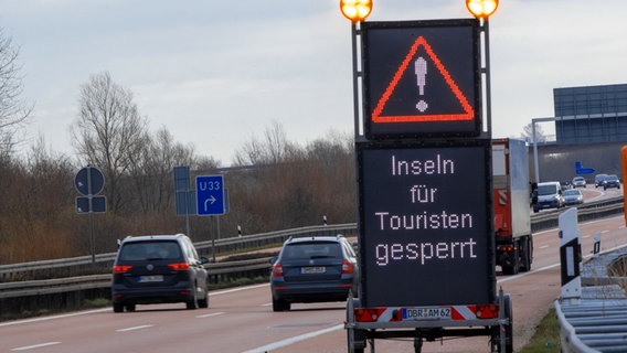 Eine mobile Informationstafel steht an der Autobahn A20 und zeigt den Schriftzug "Inseln für Touristen gesperrt". © dpa-Bildfunk Foto: Jens Büttner