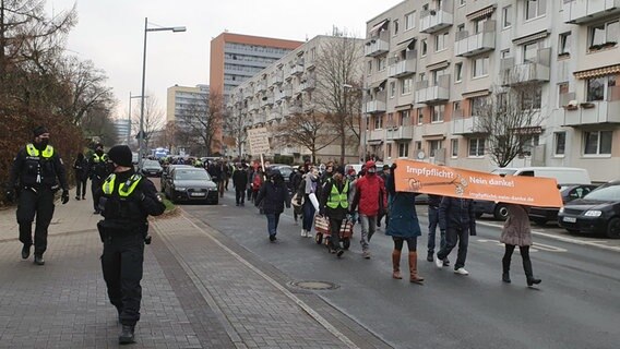 Mehrere Menschen ziehen mit Plakaten gegen die Corona-Maßnahmen durch die Innenstadt von Schwerin. © NDR Foto: Fabian Weisshaupt