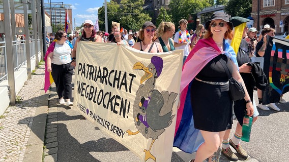 Eine Gruppe von Menschen hält einen Banner mit der Aufschrift "Patriarchat wegblocken" © NDR 