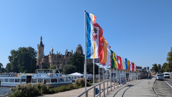 In Sichtweite des Schlosses wehen wenige Tage vor der Einheitsfeier in Schwerin die 16 Flaggen der Bundesländer © NDR MV Foto: Chris Loose/ NDR MV