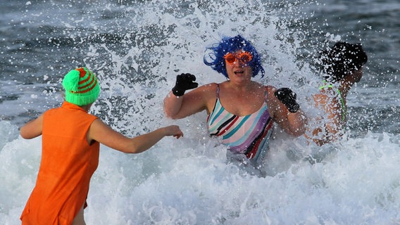 Bei Minusgraden platschen die Warnemünder Eisbader in der Ostsee. © dpa Foto: Bernd Wüstneck