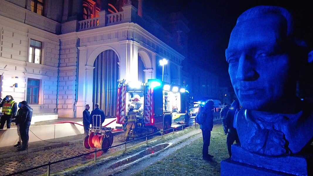 Menschen und Einsatzfahrzeuge stehen nach einem Brandalarm am Mecklenburgischen Staatstheater in Schwerin