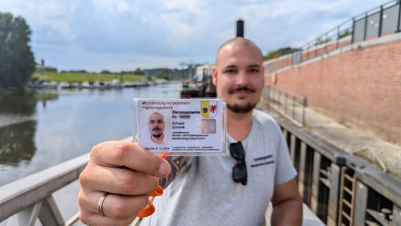 Fischereiaufseher Dominik Schwab zeigt seinen Ausweis in die Kamera. © NDR Foto: Franz Fanter