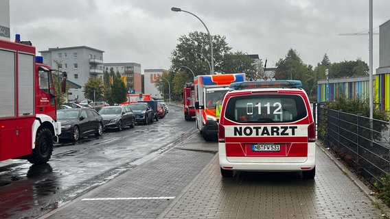 Einsatzwagen von Feuerwehr und Rettungsdienst tummeln sich auf einer Straße vor einer Schule in Neubrandenburg. © NDR Foto: Felix Baenz