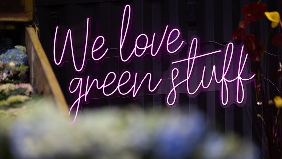 We love green stuff" steht an einer Wand in einer Messehalle auf der Grünen Woche © dpa Foto: Hannes P. Albert