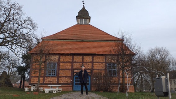 Peter Balsam, der Vorsitzende des Fördervereins Schlosskapelle Remplin vor der Fachwerkkapelle. © NDR Foto: Beatrice Böse