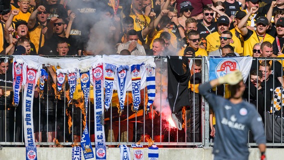 Fans von Dynamo Dresden im K-Block verbrennen Rostocker Fanschals im eigenen Stadion. Das Spiel gegen Hansa Rostock ist als Hochrisikospiel eingestuft. © NDR Foto: Robert Michael