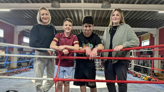 Julia Pietschmann (l.) und Chiara Schreiter stehen zusammen mit den beiden Teilnehmern der Rostocker Hobby Lobby Michael Bliss (2. v. l.) und Berat Durmaz in einem Boxring. © NDR, Carolin Beyer Foto: Carolin Beyer