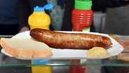 Eine Bratwurst mit Brot und Senf liegt auf der Auslage eines Imbisses © picture alliance / Stefan Sauer/dpa-Zentralbild/dpa | Stefan Sauer Foto: picture alliance / Stefan Sauer/dpa-Zentralbild/dpa | Stefan Sauer