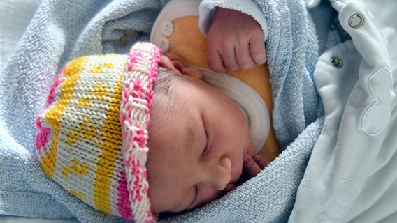 Ein neugeborenes Baby schlummert in einer Decke. © Klinikum Südstadt Rostock Foto: Joachim Kloock