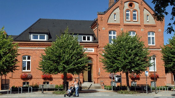 Das Rathaus von Lübz: Ein zweistöckiges Backsteingebäude mit zwei Bäumen davor. © dpa-Zentralbild Foto: Jens Büttner