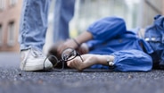 Ein Mädchen liegt mit zerbrochener Brille auf dem Boden des Schulhofes. © Ute Grabowski/imago/phototek Foto: Ute Grabowski/imago/phototek