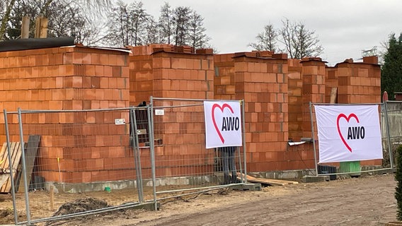 Halb feriger Klinker-Rohbau, davor Bauzäune mit AWO-Bannern. © Pressestelle der Hansestadt Wismar 